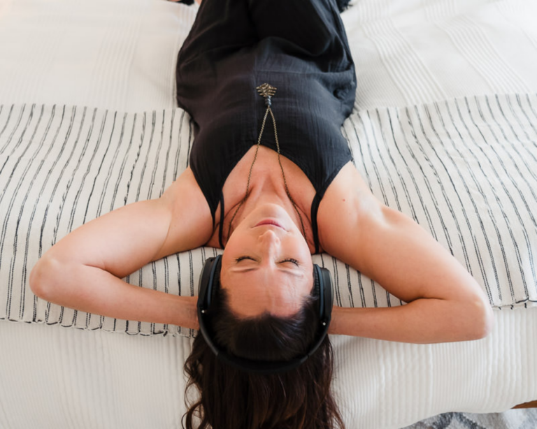 Laura lying on a bed with hands behind her head